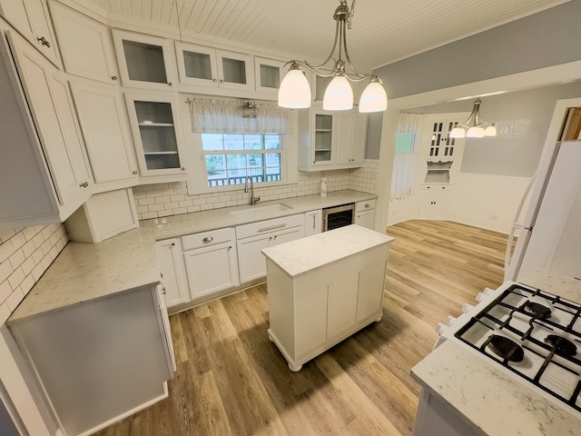 kitchen featuring light hardwood / wood-style floors, a center island, hanging light fixtures, and sink