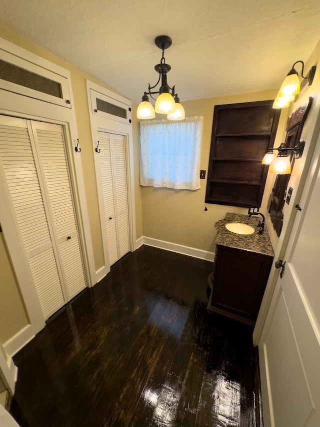 bathroom featuring an inviting chandelier, vanity, and hardwood / wood-style flooring