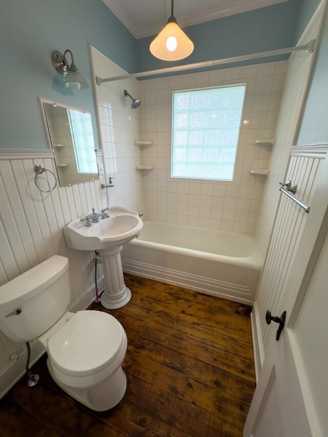 bathroom with hardwood / wood-style floors, tiled shower / bath combo, toilet, and crown molding