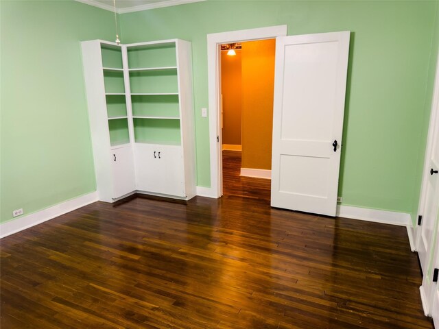 unfurnished bedroom with dark hardwood / wood-style flooring and ornamental molding