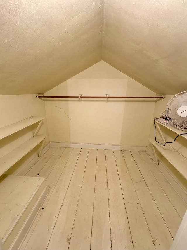 spacious closet featuring hardwood / wood-style floors and lofted ceiling