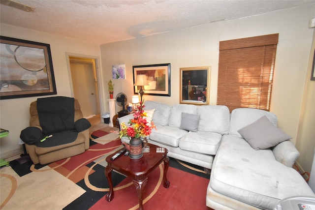 living room featuring carpet and a textured ceiling