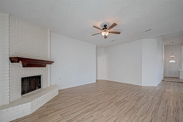 unfurnished living room with a textured ceiling, light hardwood / wood-style floors, and ceiling fan