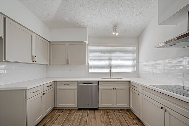 kitchen with gray cabinetry, dishwasher, wall chimney range hood, sink, and a textured ceiling