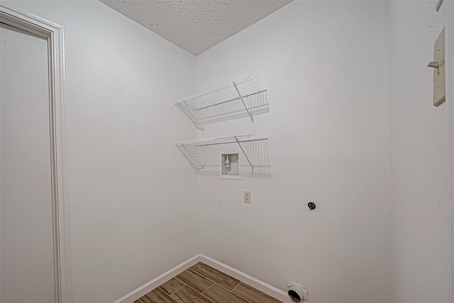 laundry room featuring hardwood / wood-style floors, washer hookup, a textured ceiling, and hookup for an electric dryer