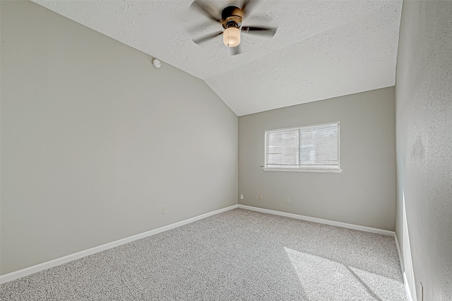 carpeted spare room with a textured ceiling, ceiling fan, and lofted ceiling