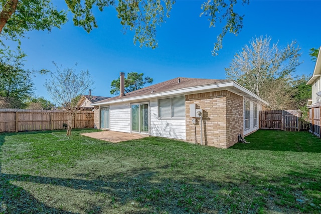 rear view of property with a lawn and a patio