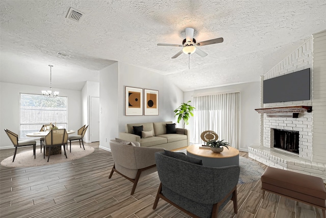 living room with hardwood / wood-style floors, a fireplace, a textured ceiling, and vaulted ceiling