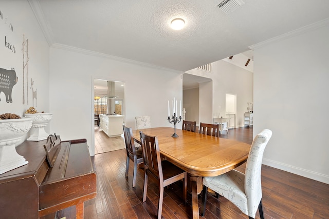 dining space featuring a textured ceiling, hardwood / wood-style flooring, and ornamental molding