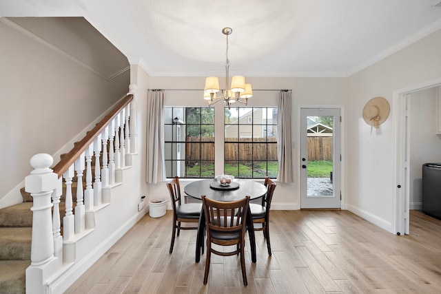 dining space with a notable chandelier, ornamental molding, and light hardwood / wood-style flooring