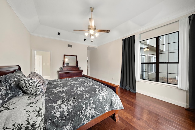 bedroom with a tray ceiling, ceiling fan, crown molding, and dark hardwood / wood-style floors