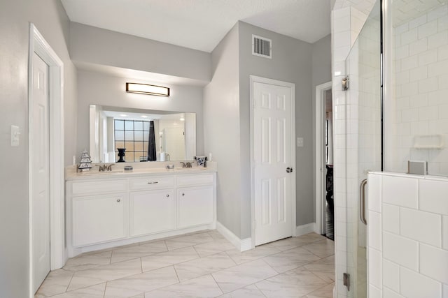 bathroom featuring vanity, a textured ceiling, and walk in shower