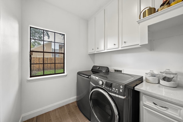 laundry room featuring hardwood / wood-style floors, cabinets, and independent washer and dryer