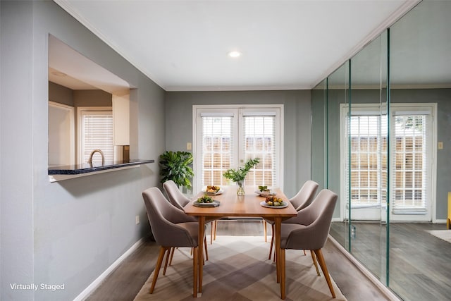 dining area with hardwood / wood-style floors, plenty of natural light, and ornamental molding