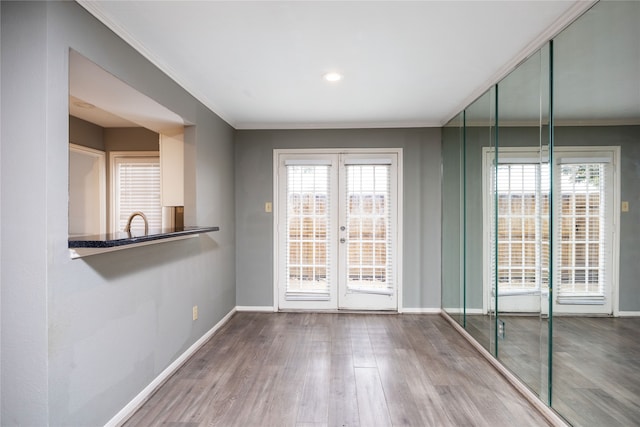 doorway to outside with hardwood / wood-style flooring, ornamental molding, sink, and french doors