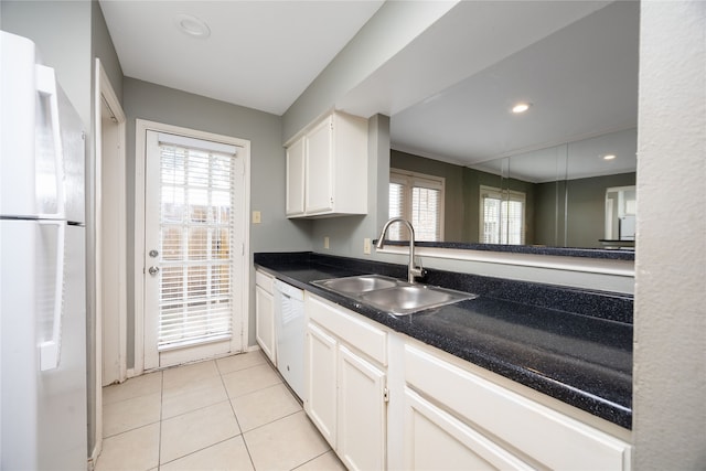 kitchen with white appliances, white cabinetry, a wealth of natural light, and sink