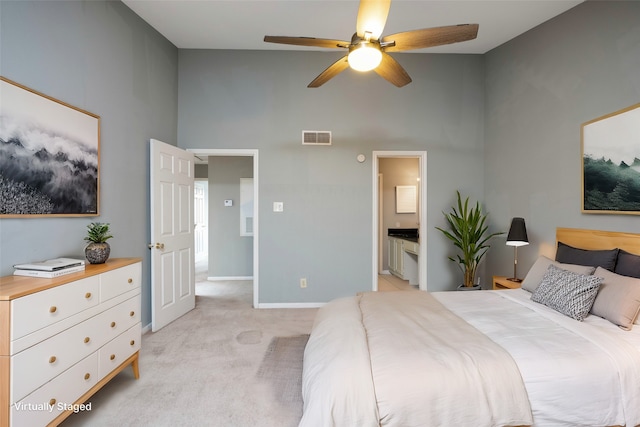 carpeted bedroom featuring ceiling fan, a high ceiling, and connected bathroom