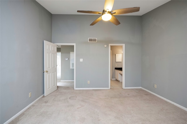 unfurnished bedroom featuring ensuite bathroom, ceiling fan, and light colored carpet