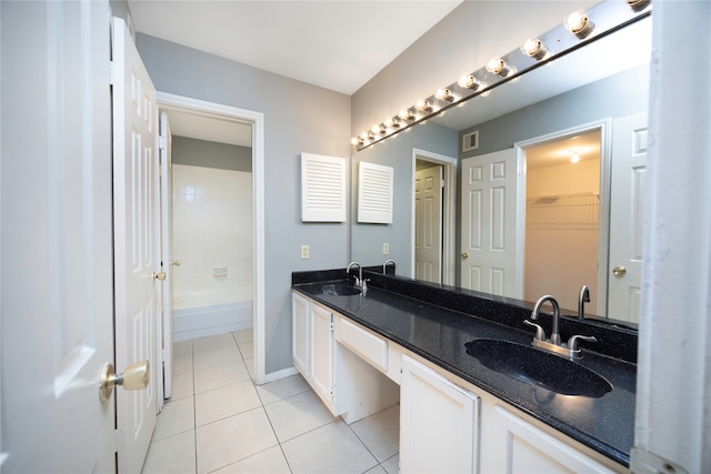 bathroom with tile patterned floors, a tub to relax in, and vanity