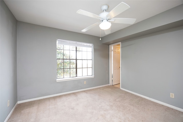 carpeted spare room with ceiling fan