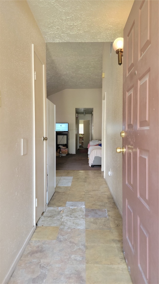 hall featuring a textured ceiling