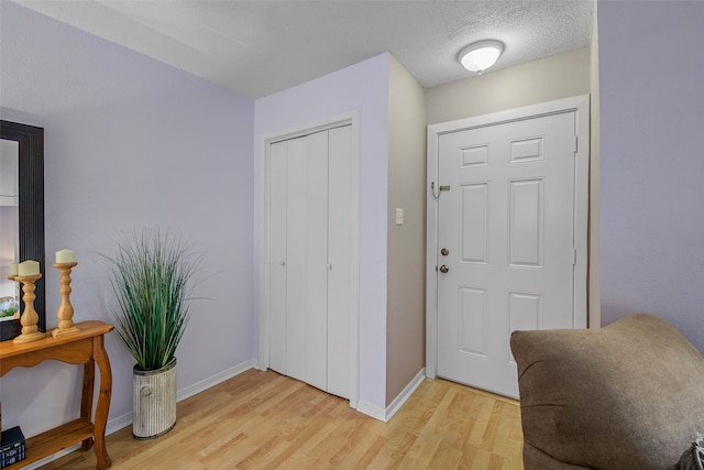 entryway featuring a textured ceiling and light hardwood / wood-style flooring