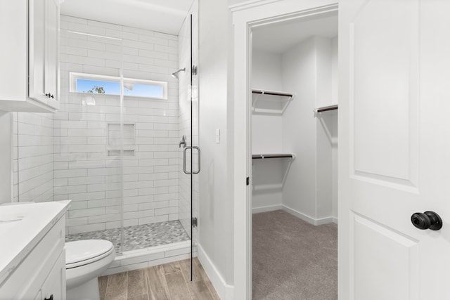 bathroom with vanity, wood-type flooring, a shower with shower door, and toilet