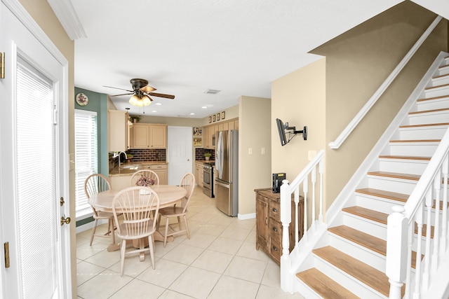 tiled dining room with ceiling fan and sink