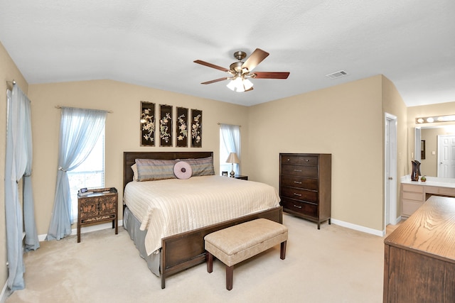 carpeted bedroom with connected bathroom, ceiling fan, and lofted ceiling