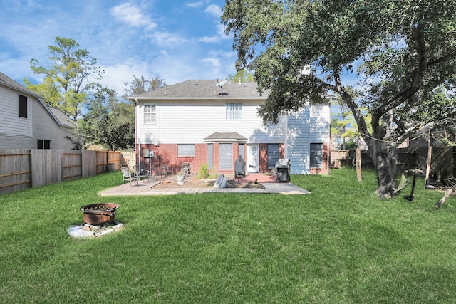 back of house featuring a fire pit, a yard, and a patio