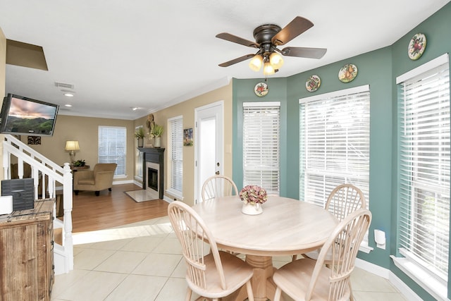 dining space featuring ceiling fan, light tile patterned floors, and ornamental molding