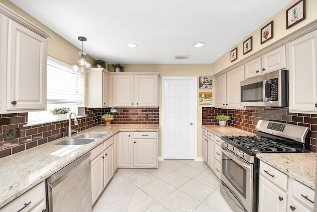 kitchen featuring decorative backsplash, appliances with stainless steel finishes, decorative light fixtures, and sink