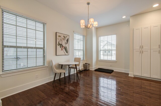 dining area featuring dark wood-type flooring and a notable chandelier