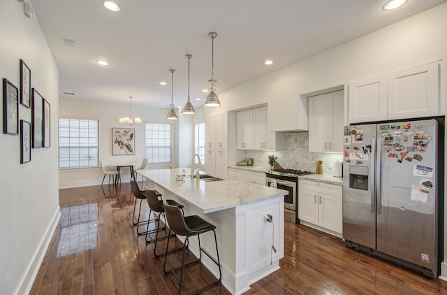 kitchen featuring a center island with sink, white cabinets, dark hardwood / wood-style floors, and appliances with stainless steel finishes