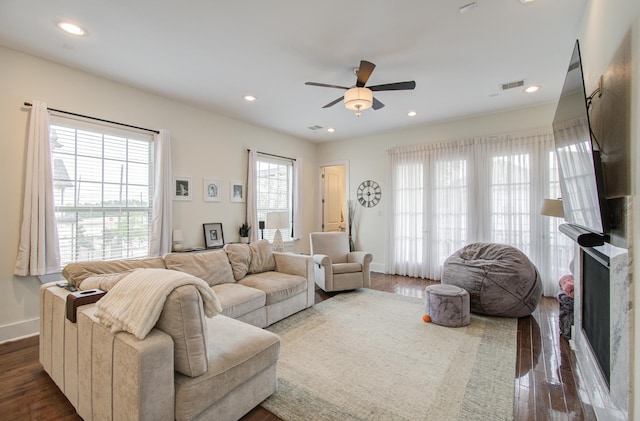 living room with dark wood-type flooring and a wealth of natural light