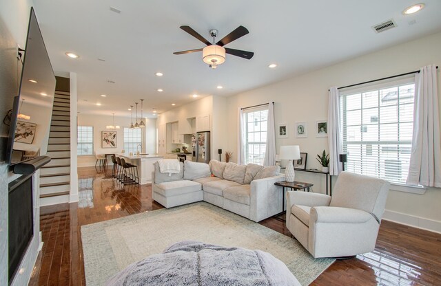 living room featuring plenty of natural light, dark hardwood / wood-style floors, and ceiling fan