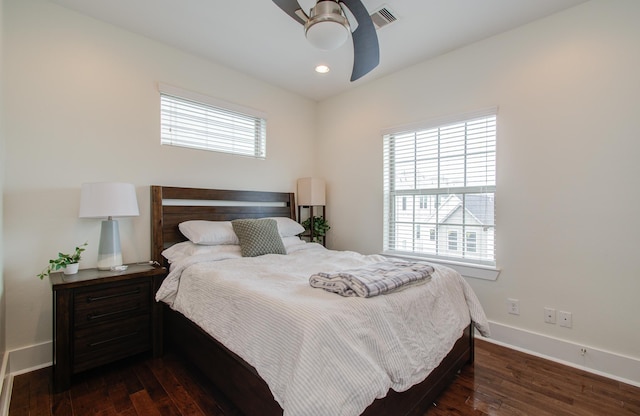 bedroom featuring dark wood-type flooring, ceiling fan, and multiple windows