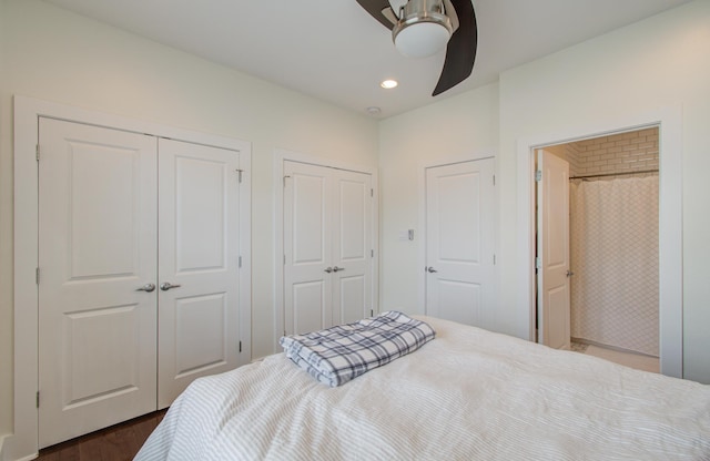 bedroom with two closets, ceiling fan, and dark hardwood / wood-style floors