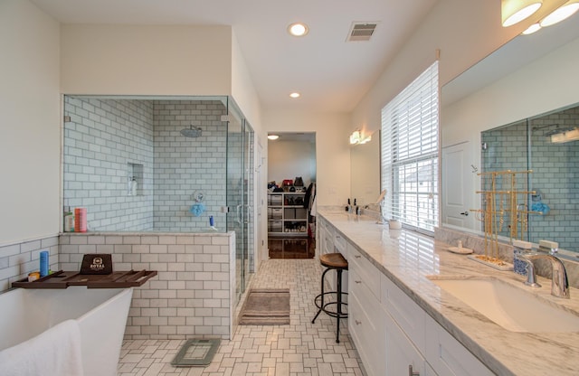 bathroom featuring tile patterned flooring, vanity, tile walls, and plus walk in shower