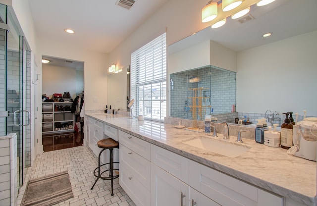 bathroom with vanity and a shower with door