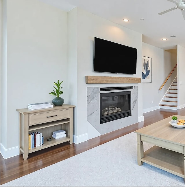 living room with ceiling fan, dark hardwood / wood-style floors, and a fireplace