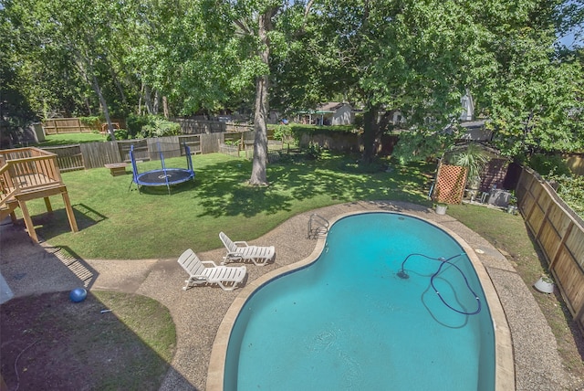 view of pool featuring a yard and a trampoline