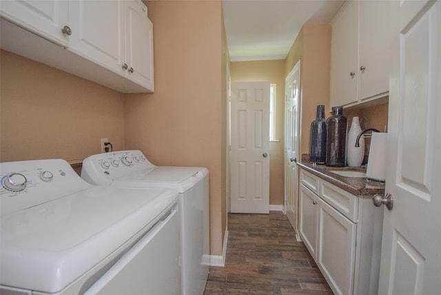 laundry room featuring washer and dryer, dark hardwood / wood-style floors, cabinets, and sink