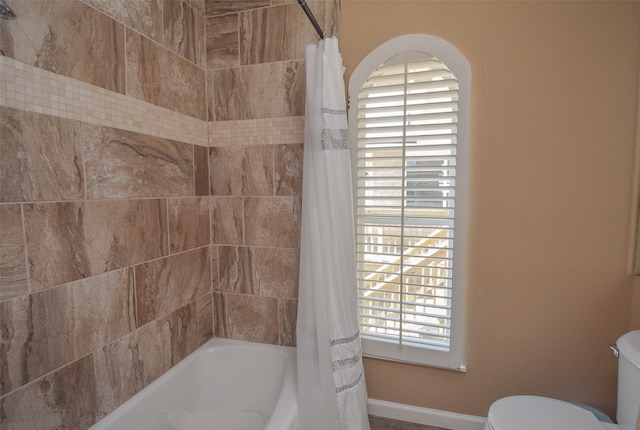 bathroom featuring toilet and shower / tub combo with curtain