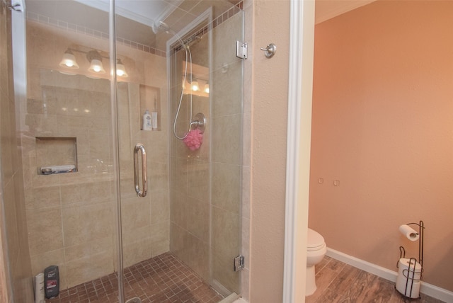 bathroom featuring walk in shower, crown molding, toilet, and hardwood / wood-style flooring