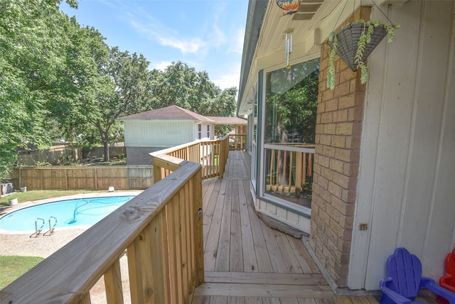 wooden deck with a fenced in pool