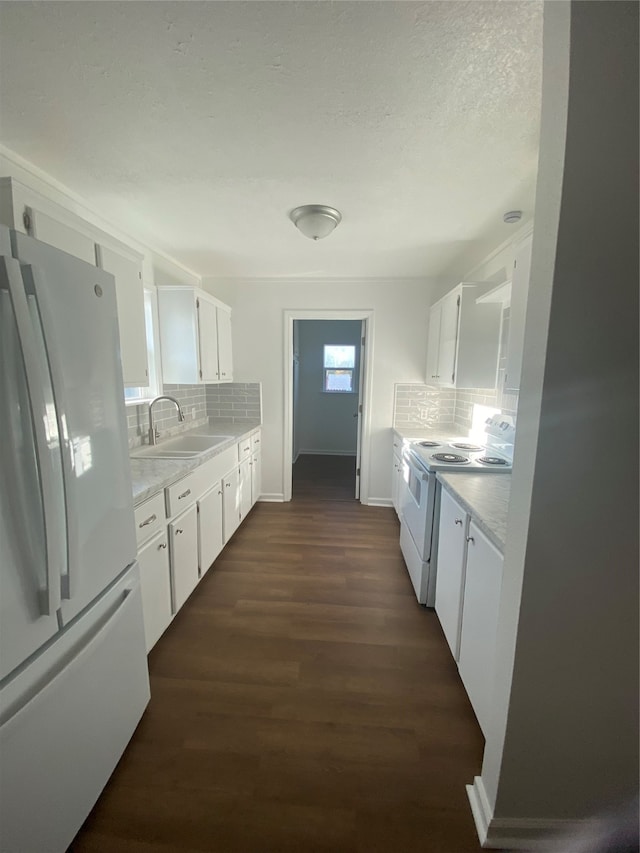 kitchen featuring white appliances, white cabinetry, and sink