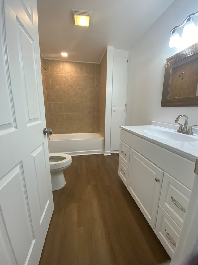 full bathroom with toilet, vanity, tiled shower / bath combo, and hardwood / wood-style flooring