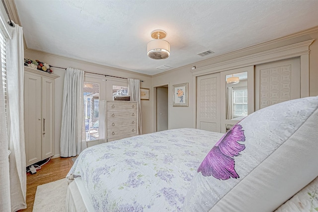 bedroom featuring crown molding and light hardwood / wood-style flooring