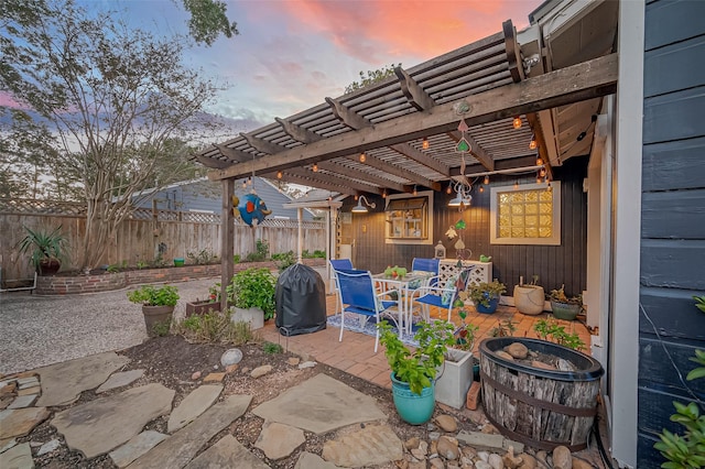 patio terrace at dusk featuring a pergola